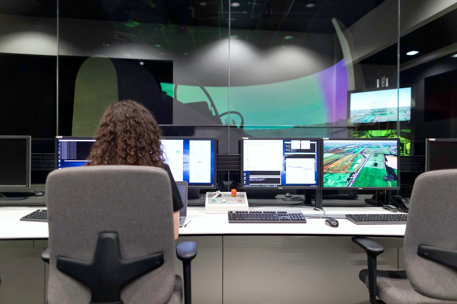 Engineer at a wall of live screens in a control room