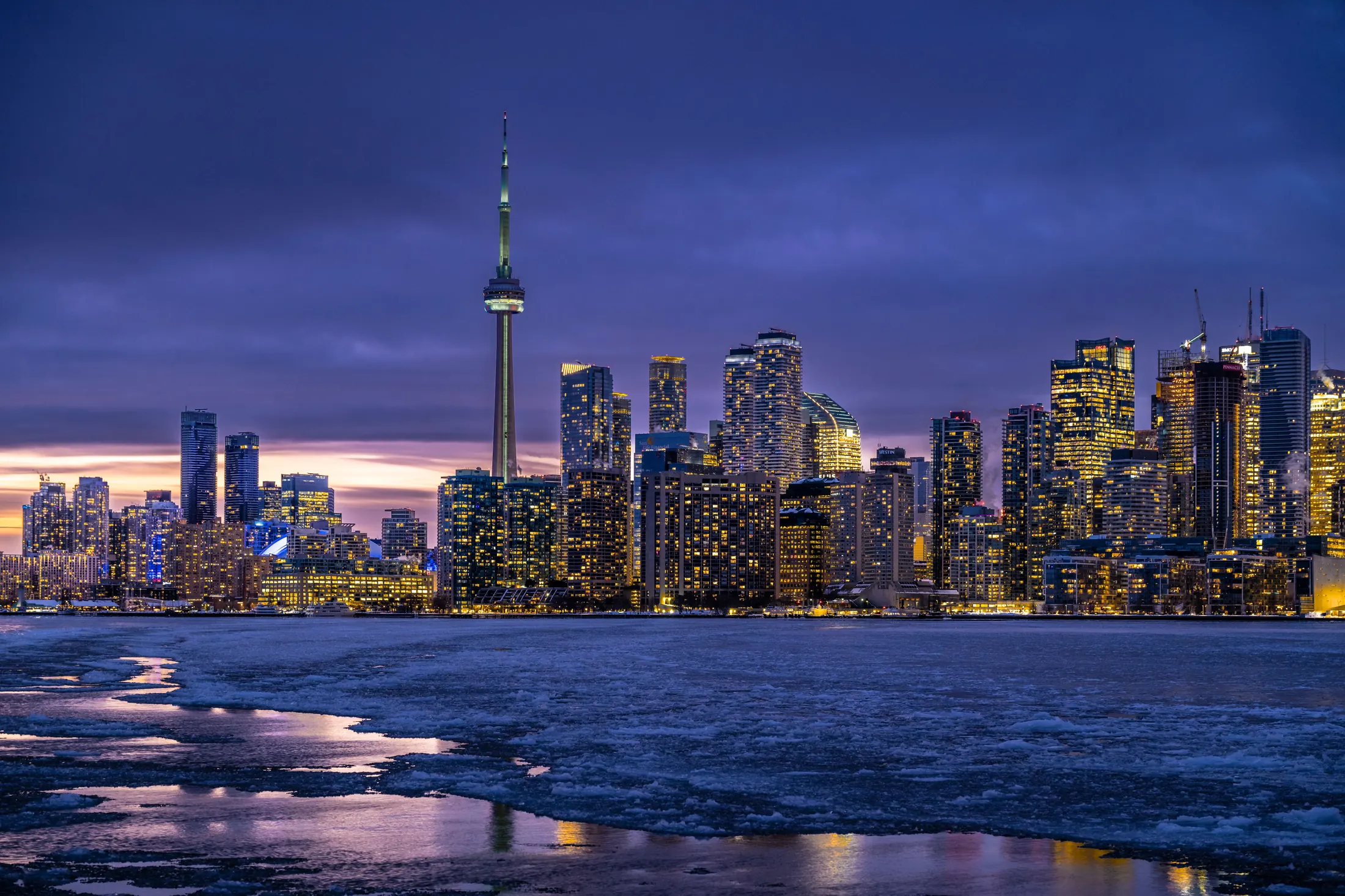 Toronto skyline at night across Lake Ontario, with the CN Tower